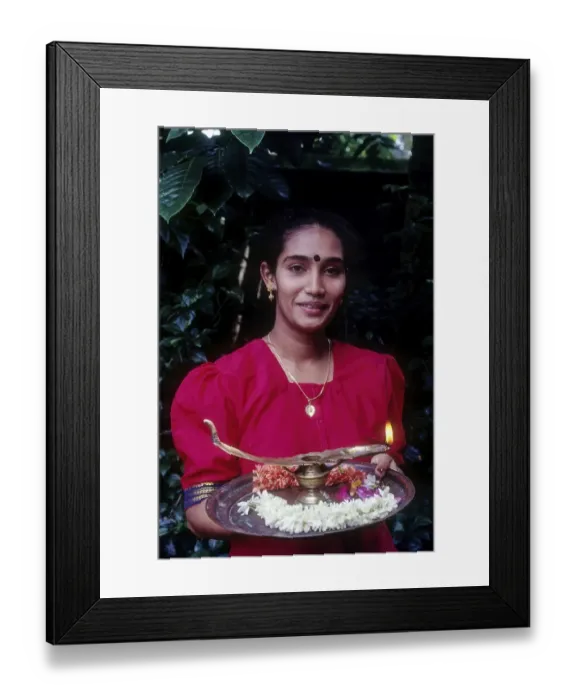 Framed Print : A girl holding oil lamp and flowers on a tray during Onam festival Framed Print : A girl holding oil lamp and flowers on a tray during Onam festival
