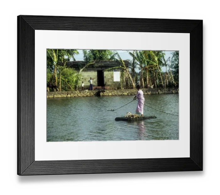 Framed Print : A woman crossing the Backwaters with the help of the rope and a country made float
