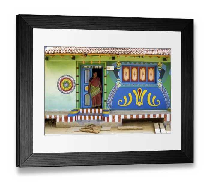 Framed Print : A woman standing at the entrance door of the village house