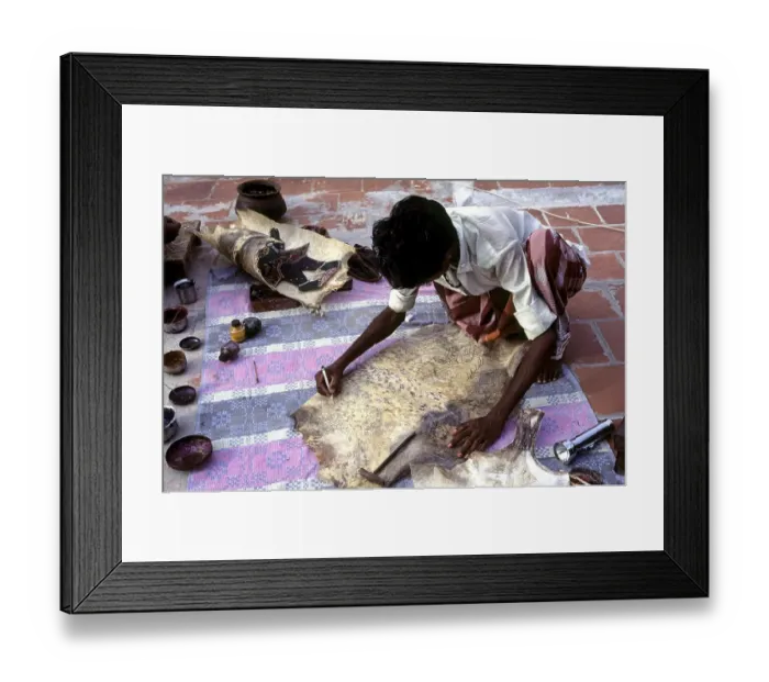 Framed Print : Puppet artist giving shape to the outline leather puppet making at Madurai
