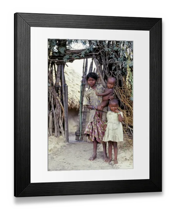 Framed Print : A tribal girl with her two sisters one standing nearby and another holding on her hip Framed Print : A tribal girl with her two sisters one standing nearby and another holding on her hip