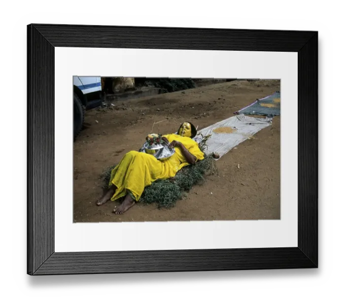 Framed Print : A woman begging lying on a bed of thorns in front of temple