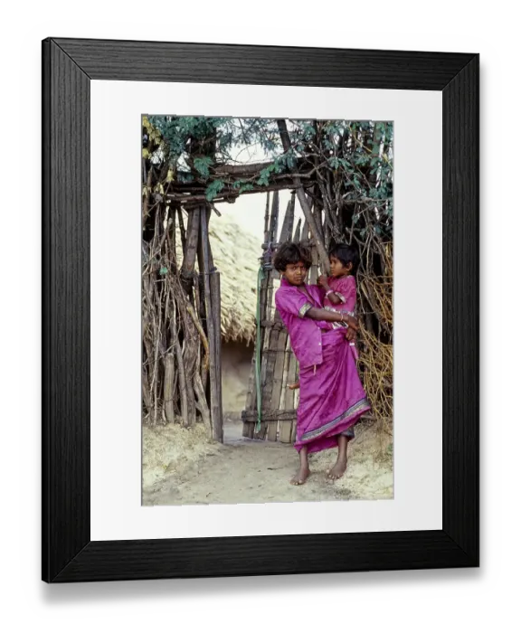 Framed Print : A tribal girl with her sister holding on her hip