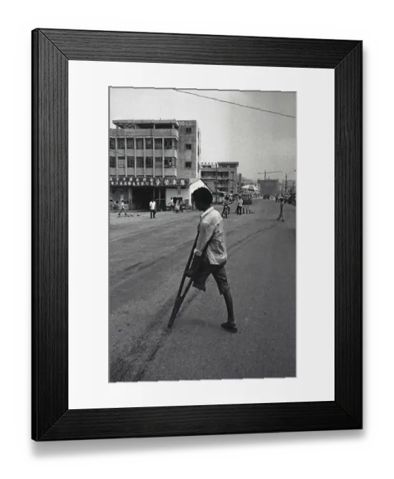 Framed Print : Southern provinces, China, circa 1982: An amputee crosses the road with the help of a crutch