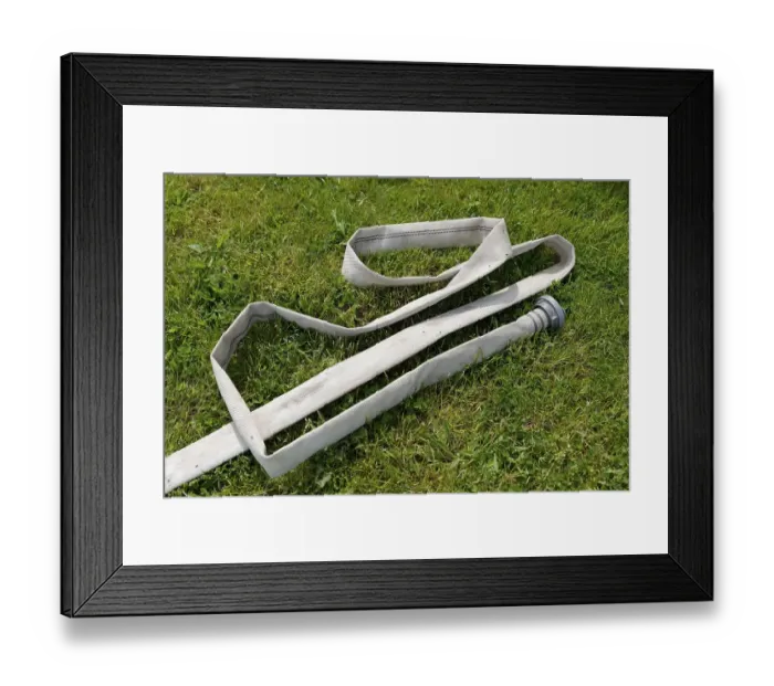 Framed Print : Fire hose in a meadow