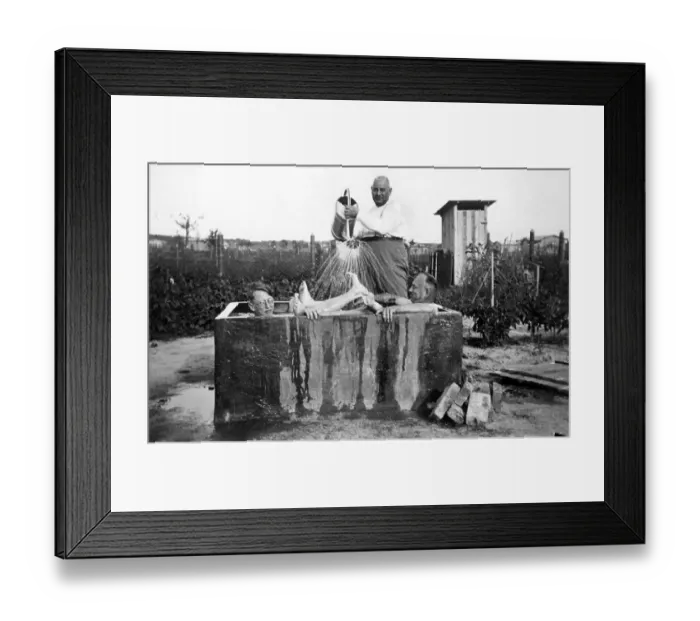 Framed Print : Overweight man pooring water over two other men Framed Print : Overweight man pooring water over two other men