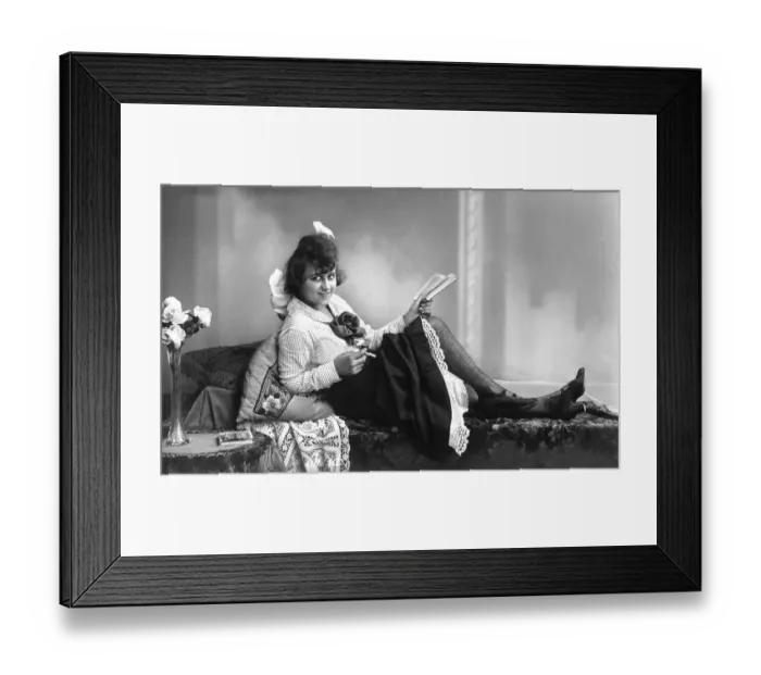 Framed Print : Woman reading and smoking on a divan