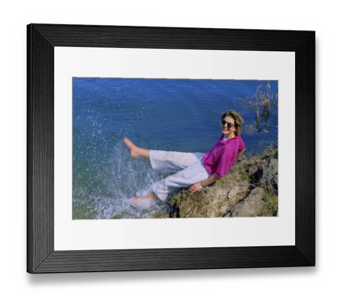 Framed Print : Young woman on the beach, feet in the water