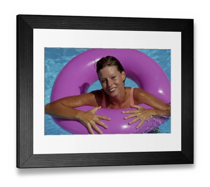 Framed Print : Young woman with swimming ring in swimming pool