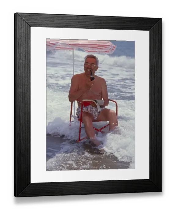 Framed Print : Older man with solar chair and sunshade by the sea