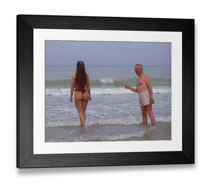 Framed Print : Older man flirts with young woman on the beach Framed Print : Older man flirts with young woman on the beach