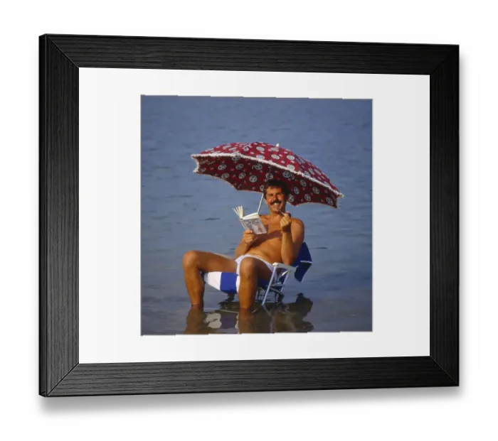 Framed Print : Young man with solar chair and sunshade on the beach Framed Print : Young man with solar chair and sunshade on the beach