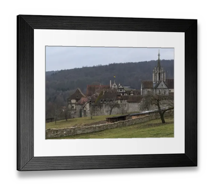 Framed Print : View of a medieval monastery with church tower and half-timbered houses on a cloudy day Framed Print : View of a medieval monastery with church tower and half-timbered houses on a cloudy day