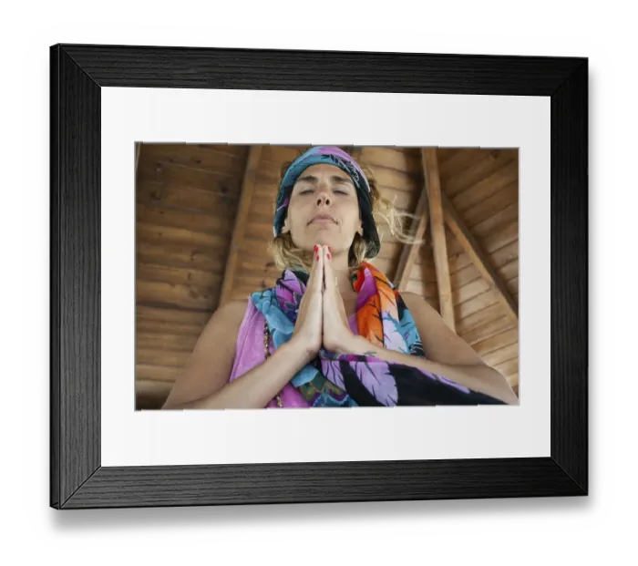 Framed Print : Low angle view of a woman clasping hands and wearing a bandana while meditating Framed Print : Low angle view of a woman clasping hands and wearing a bandana while meditating