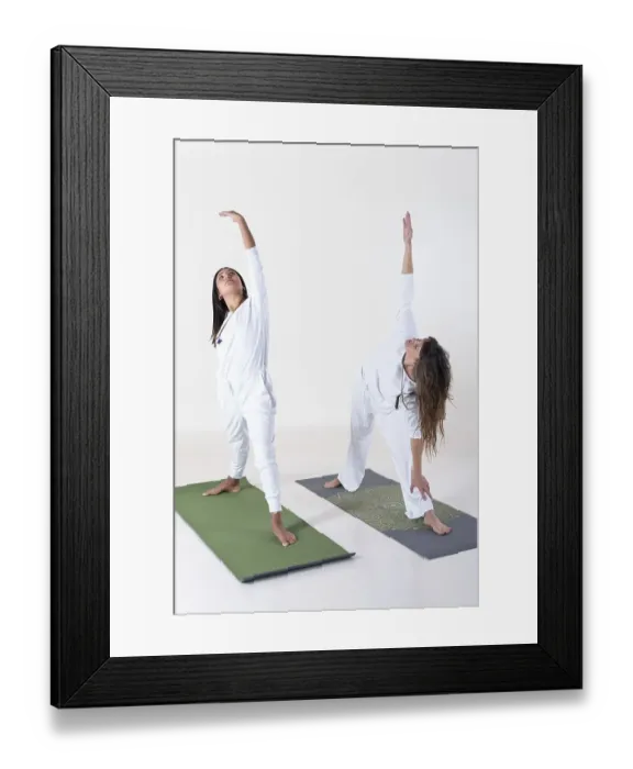 Framed Print : Two women dressed in white doing yoga over white background Framed Print : Two women dressed in white doing yoga over white background