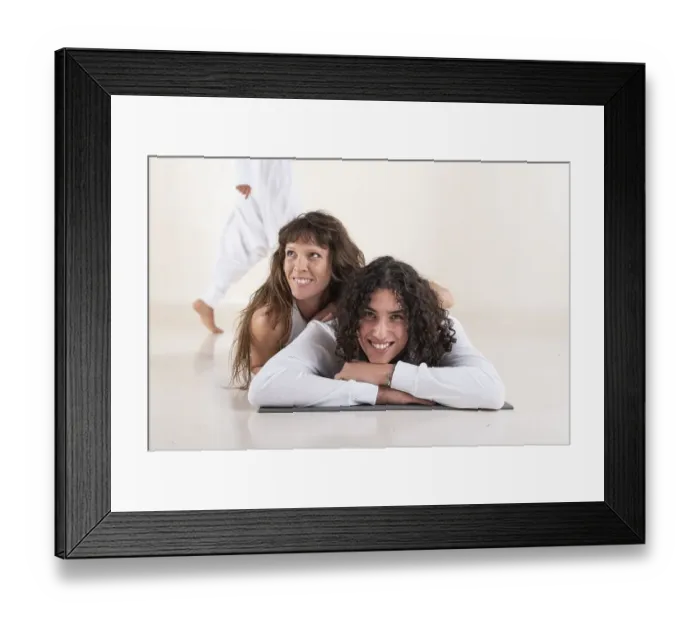 Framed Print : Portrait of a young man dressed in white yoga clothes lying on a mat while looking at camera with a friend over white Framed Print : Portrait of a young man dressed in white yoga clothes lying on a mat while looking at camera with a friend over white