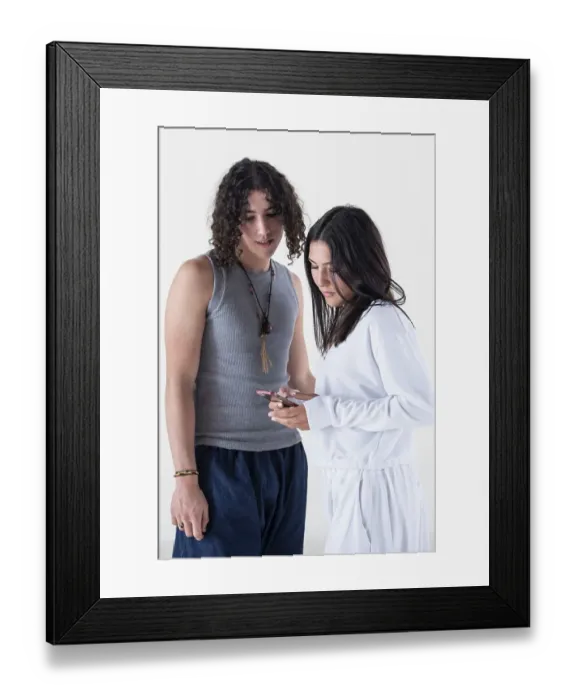 Framed Print : Portrait of a young couple dressed in yoga clothes looking a smartphone over white background Framed Print : Portrait of a young couple dressed in yoga clothes looking a smartphone over white background