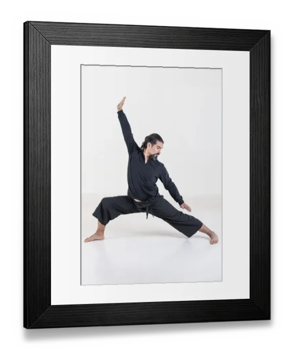 Framed Print : A man dressed in black doing yoga over white background