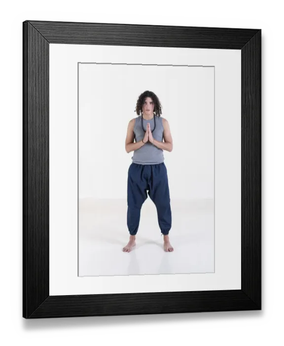 Framed Print : Young man clasping hands while looking at camera over white background