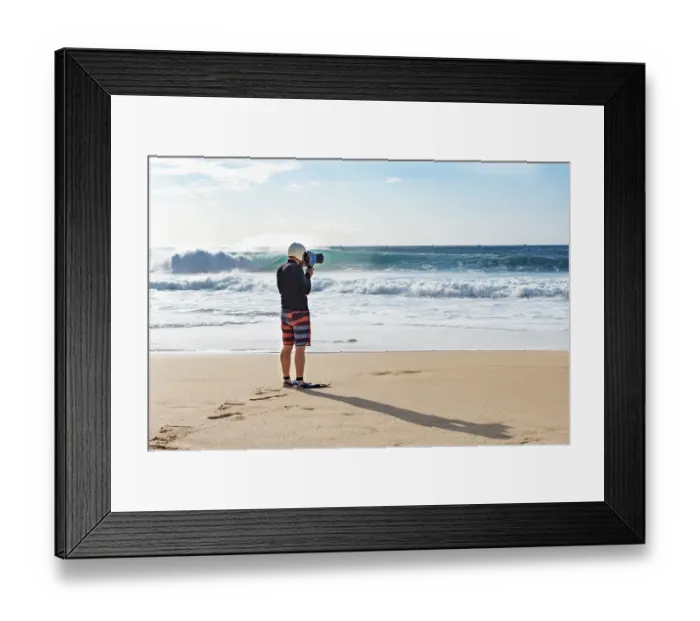 Framed Print : A surf photographer taking photographs by the shore at Banzai Pipeline