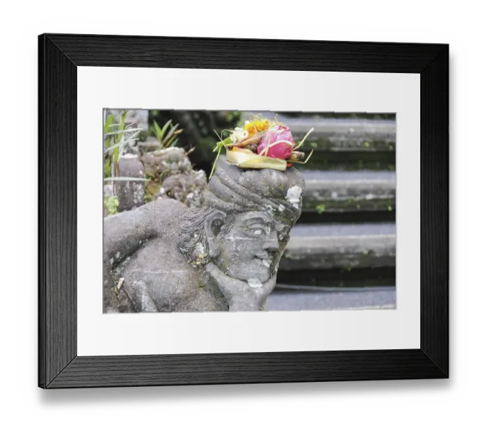 Framed Print : Balinese religious offering (canang sari) over a stone statue Framed Print : Balinese religious offering (canang sari) over a stone statue