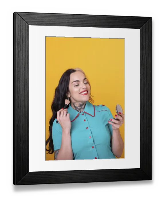 Framed Print : Attractive Woman Applying Face Powder over yellow Studio Background