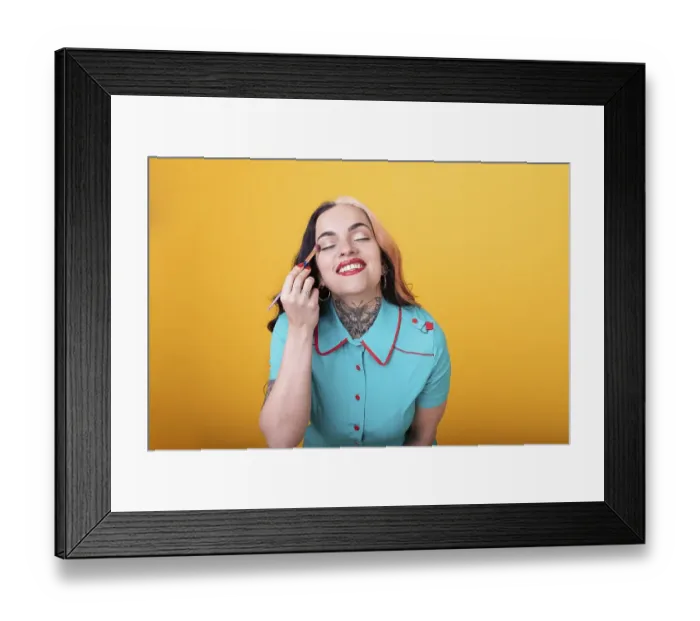 Framed Print : Attractive Woman Applying eye shadow over yellow Studio Background