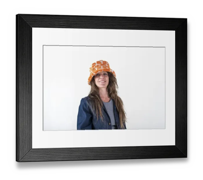 Framed Print : Portrait of a smiling woman wearing a hat and looking at camera over a white background