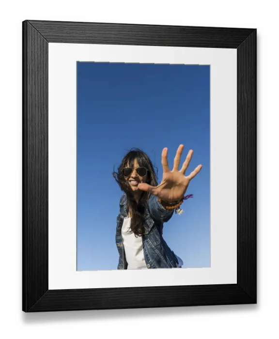 Framed Print : Low angle view of a similing woman while showing the palm of her hand