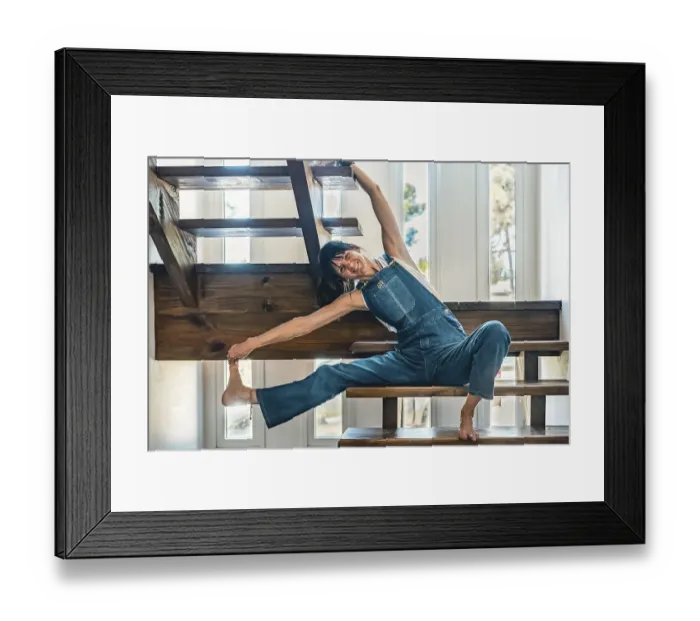 Framed Print : A woman doing stretching exercises on the stairs of her home