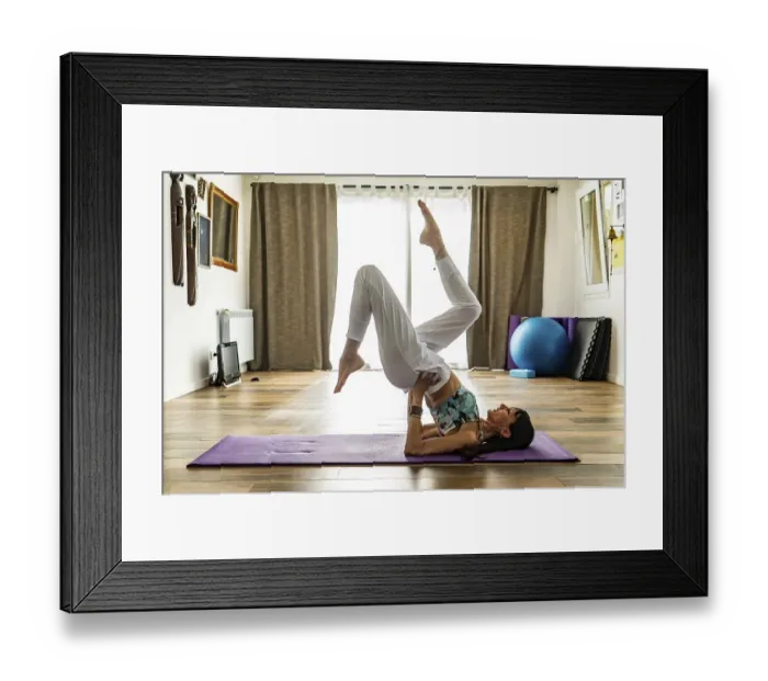 Framed Print : Side view of a woman practicing yoga on a mat Framed Print : Side view of a woman practicing yoga on a mat