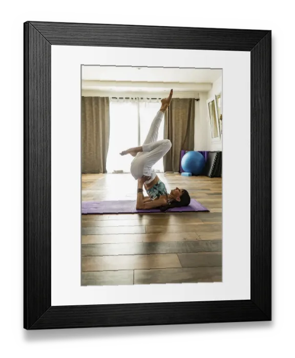 Framed Print : Side view of a woman practicing yoga on a mat Framed Print : Side view of a woman practicing yoga on a mat