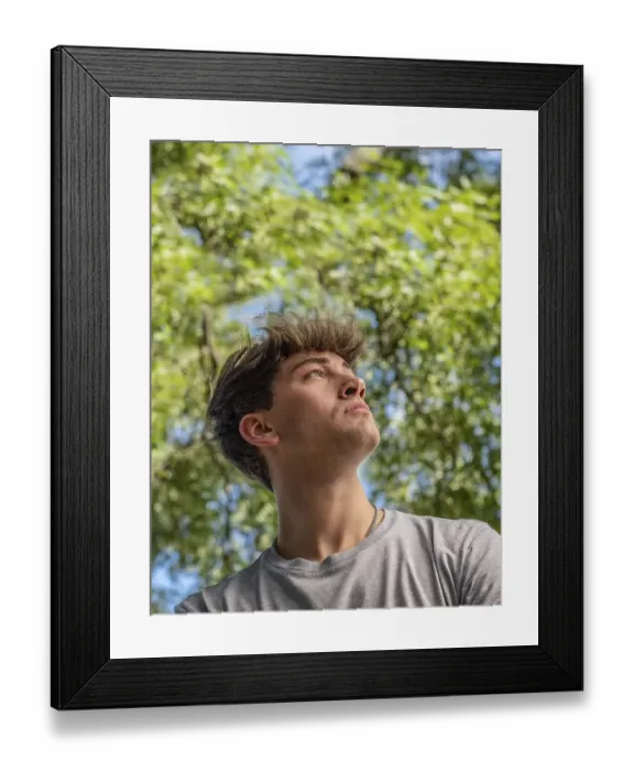 Framed Print : Side view of a young man who is looking up over nature background