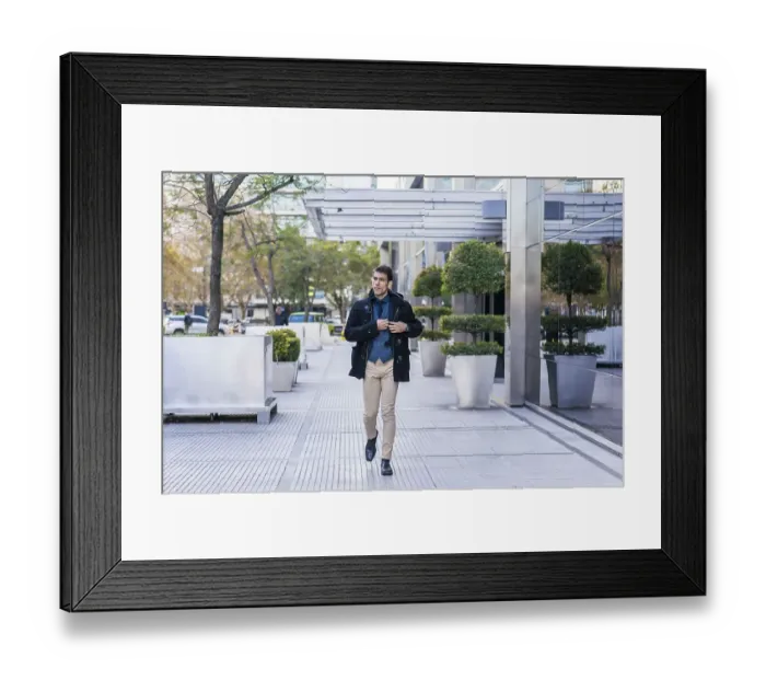 Framed Print : A businessman taking off the mobile phone from his pocket while walking in the street