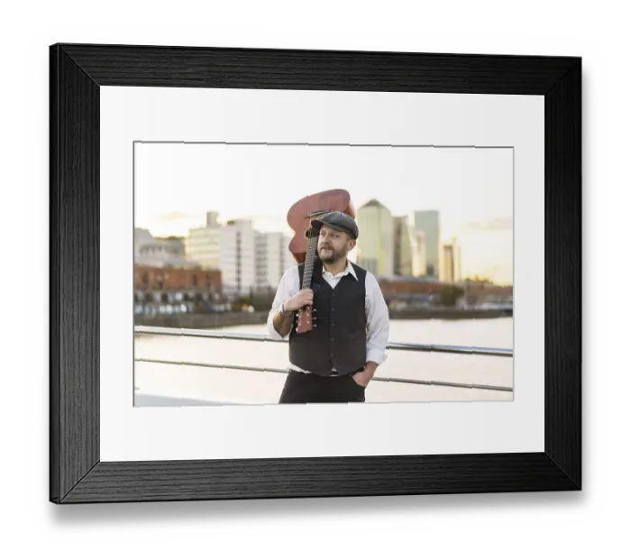 Framed Print : Portrait of a musician looking away while holding his guitar on his shoulder Framed Print : Portrait of a musician looking away while holding his guitar on his shoulder