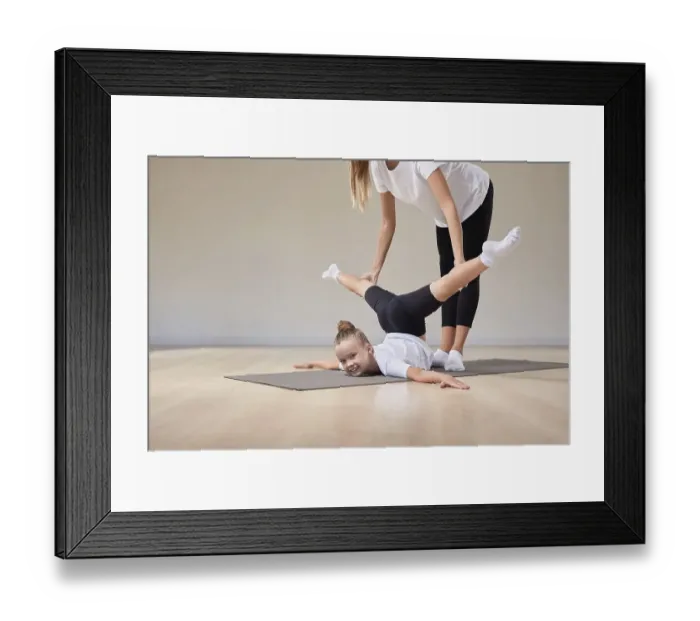 Framed Print : Beautiful female teacher helps a little girl stretch in a gymnastics class. The concept of education, sports, Pilates, stretching, healthy lifestyle