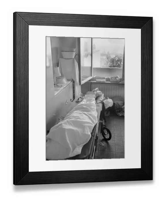Framed Print : 03.04.1982, East Berlin, Biesdorf district, old people's and nursing home, nursing ward, a woman who died during the night lies wrapped in a sheet on a stretcher, Biesdorf, Marzahn-Hellersdorf, GDR
