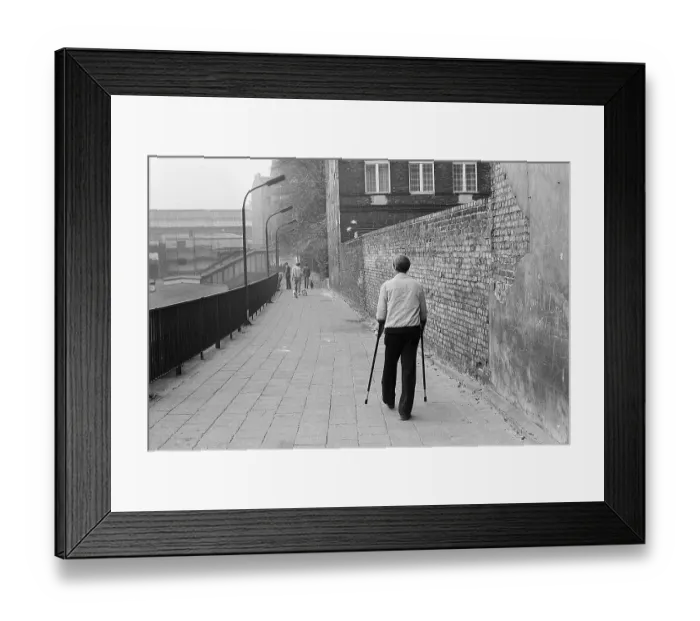 Framed Print : 10.10.1983 GDR East Berlin, Prenzlauer Berg, man with crutches walking to Schoenhauser Allee S-Bahn station, East Berlin, Berlin-Prenzlauer Berg, GDR GDR