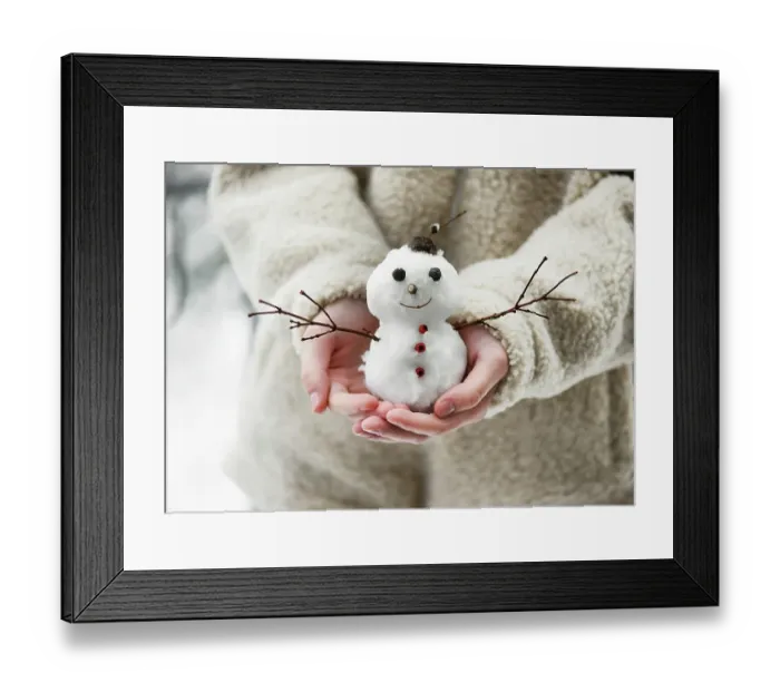 Framed Print : Little snowman, decorated with twigs and berries, held in children's hands in a winter garden with lots of snow. Winter atmosphere