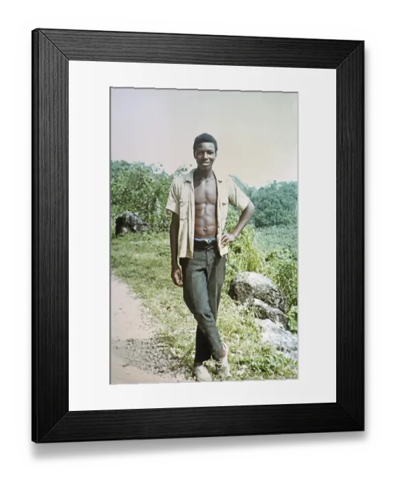 Framed Print : Full-length portrait of a young man with open shirt showing his chest, rural location, Jamaica, 1970, Central America