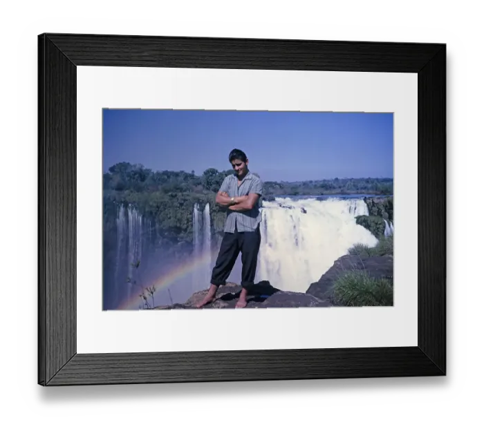 Framed Print : Male tour guide standing barefoot at the edge of the Iguazu Falls on the Iguazu River, on the border between Brazil and Argentina, South America, 1962