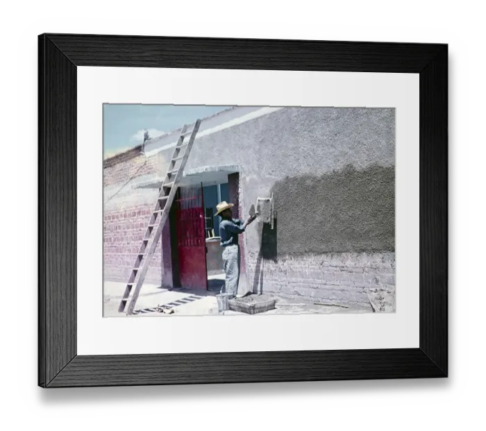 Framed Print : Construction worker throwing cement through a sieve to make wall panelling over modern red bricks, Mexico around 1961