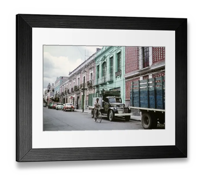 Framed Print : Man cycling past parked cars and houses, street in Puebla, Mexico, around 1961, Central America