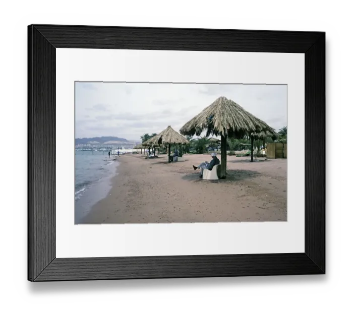 Framed Print : Tourists sitting in the shade on a sandy beach on the Red Sea coast, Aqaba. Jordan, 1998