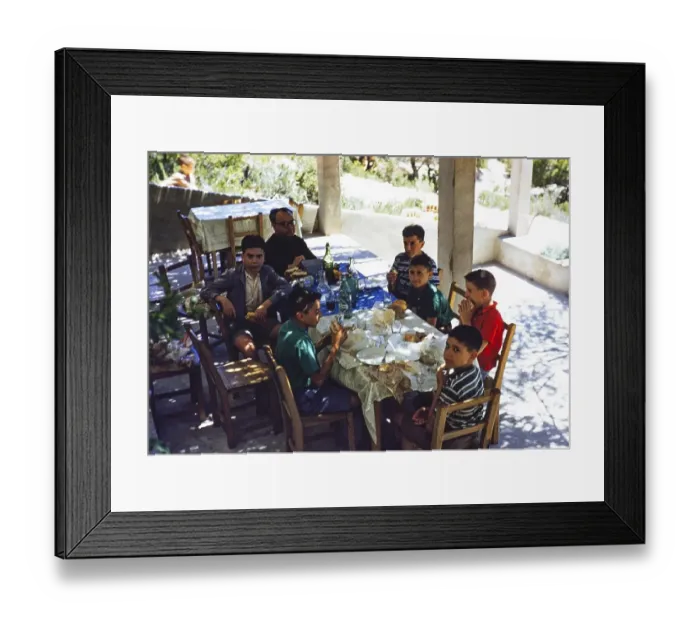 Framed Print : Gruppe von Jungen, die an einem schattigen Tisch in einem Cafe Sandwiches essen, begleitet von einem Mann, moeglicherweise einem Priester, Insel Ibiza, Balearen, Spanien, 1950er Jahre