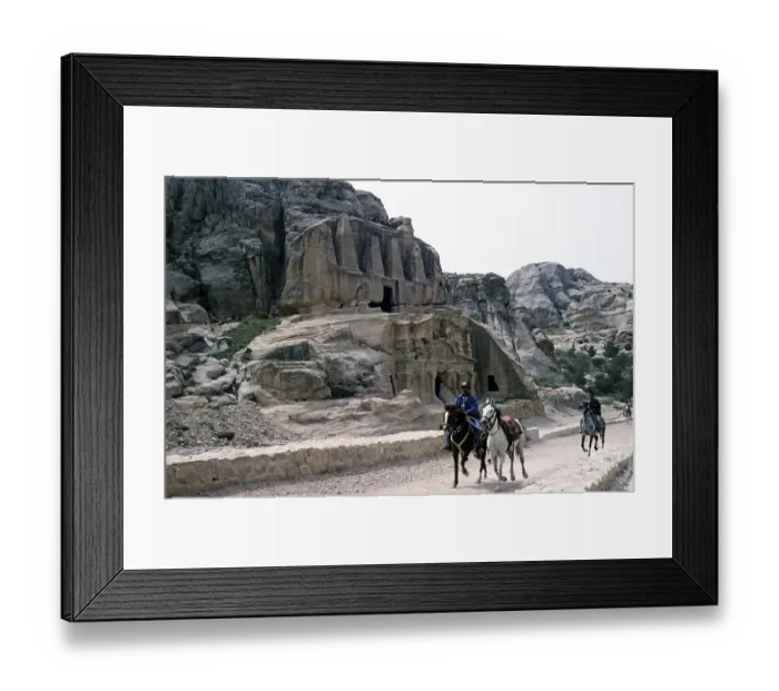 Framed Print : Local horsemen ride past the rock-cut tombs of the archaeological site of Petra, Jordan (1998)