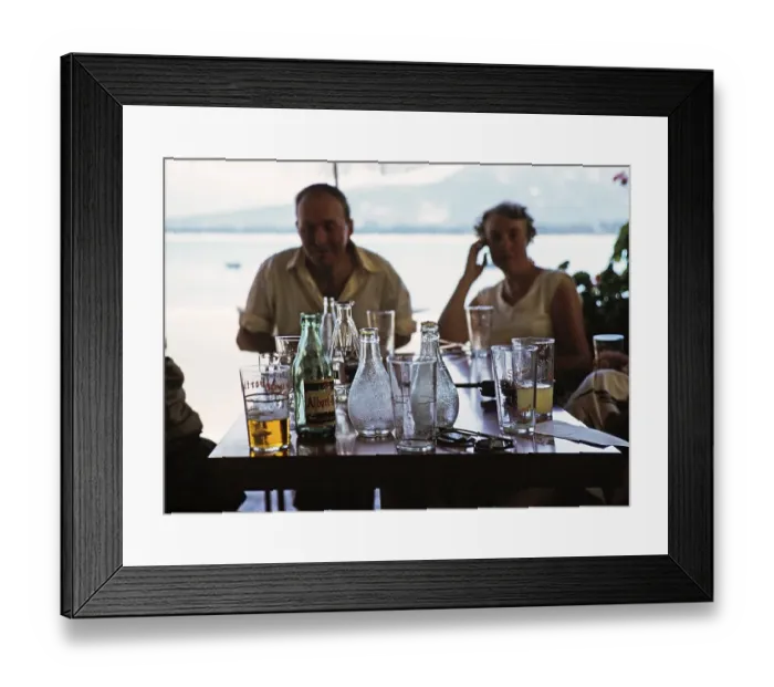Framed Print : Menschen um einen Tisch mit Getraenken und Flaschen in einem Hafencafe in Calvi, Korsika, Frankreich, 1950er Jahre