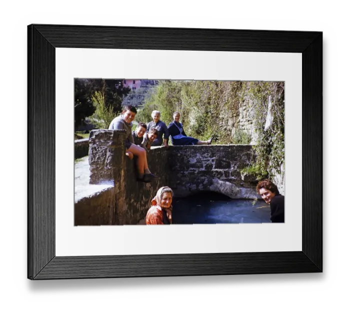 Framed Print : Woman and boys of an Italian family sitting on a bridge in a village, Italy 1957