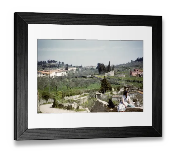 Framed Print : English tourist sitting on a wall in a village, Italy 1957