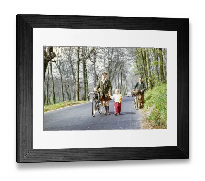 Framed Print : Man riding a bicycle and holding a child by the hand, England, UK, 1956 NB) poor sharpness Framed Print : Man riding a bicycle and holding a child by the hand, England, UK, 1956 NB) poor sharpness
